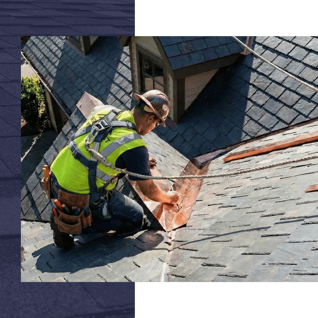 A professional roofer in full safety gear and harness precisely installing new roofing materials on a steep residential roof.