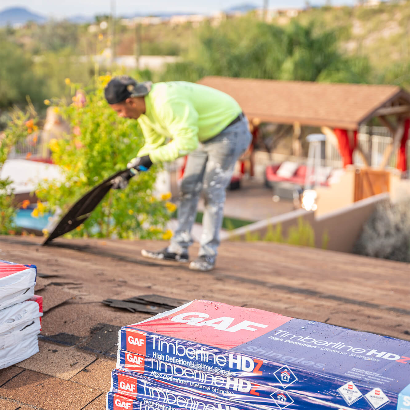 A West Coast Roofing contractor working on instaling shingles to a roof